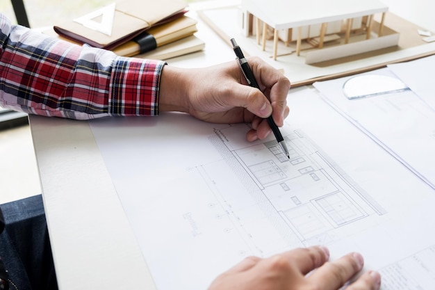 Imagem recortada de um arquiteto fazendo um plano no escritório