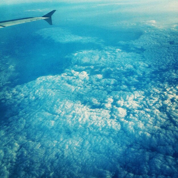 Foto imagem recortada de um avião voando sobre nuvens