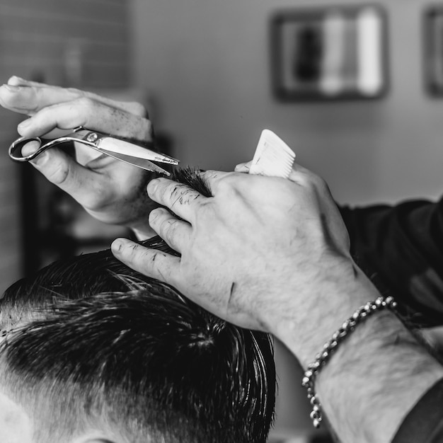 Imagem recortada de um cabeleireiro cortando o cabelo à mão