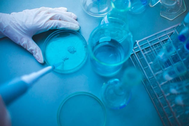 Imagem recortada de um cientista experimentando um produto químico azul em laboratório