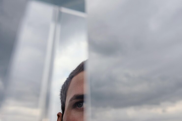 Foto imagem recortada de um jovem olhando para longe pelo espelho com reflexo