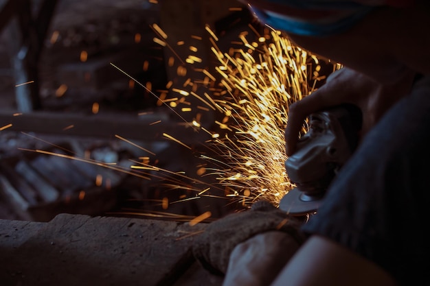 Imagem recortada de um trabalhador masculino cortando metal em uma fábrica
