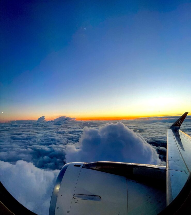 Foto imagem recortada de uma asa de avião contra o céu durante o pôr do sol