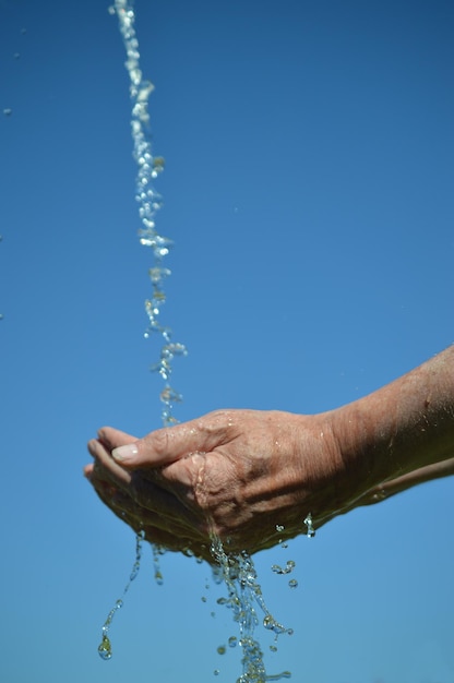 Foto imagem recortada de uma pessoa lavando as mãos contra um céu azul claro