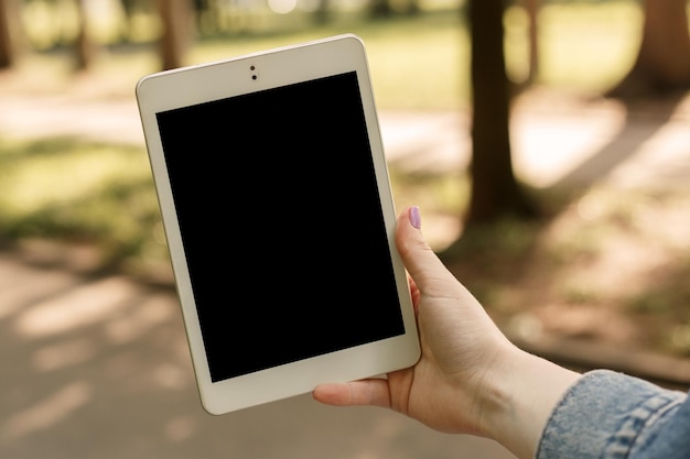 Imagem simulada de mulher segurando tablet no parque