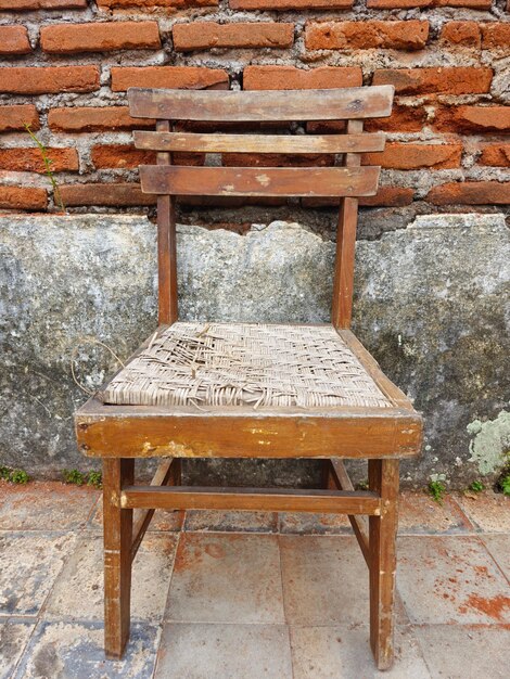 Foto imagem vertical de uma cadeira antiga e antiga feita de madeira de teca e rattan vista frontal