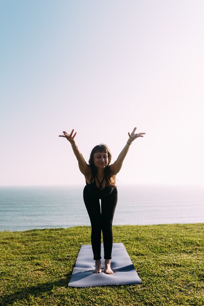 Foto imagem vertical de uma mulher magra praticando ioga. mulher estica o corpo ao ar livre. copie o espaço