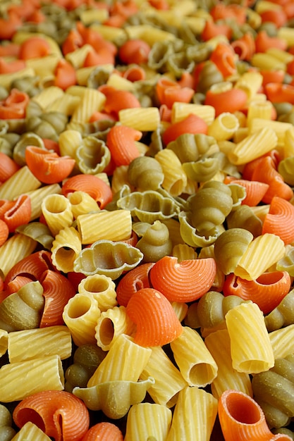Imagem vertical de uma pilha de massa de vegeroni crua de três cores com foco seletivo