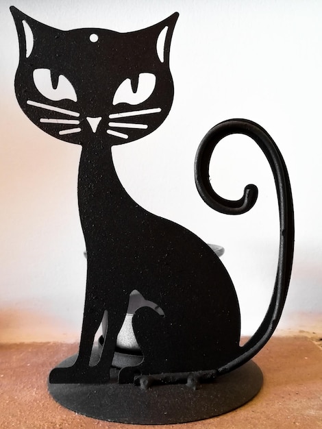 Imagem vertical do suporte de velas em forma de casa conceito silhueta de gato preto e decoração de casa