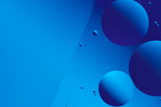 Imagen abstracta con burbujas flotantes azules y púrpuras sobre un fondo azul oscuro que crea un efecto visual tranquilo y minimalista