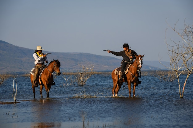 La imagen de la acción del vaquero es montando un caballo y sosteniendo una pistola en la mano.