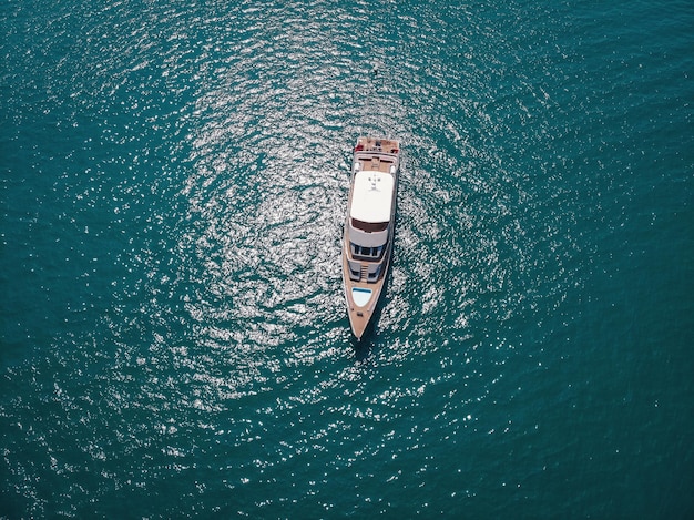 Imagen aérea de un yate aislado con diseño de madera marrón en el mar