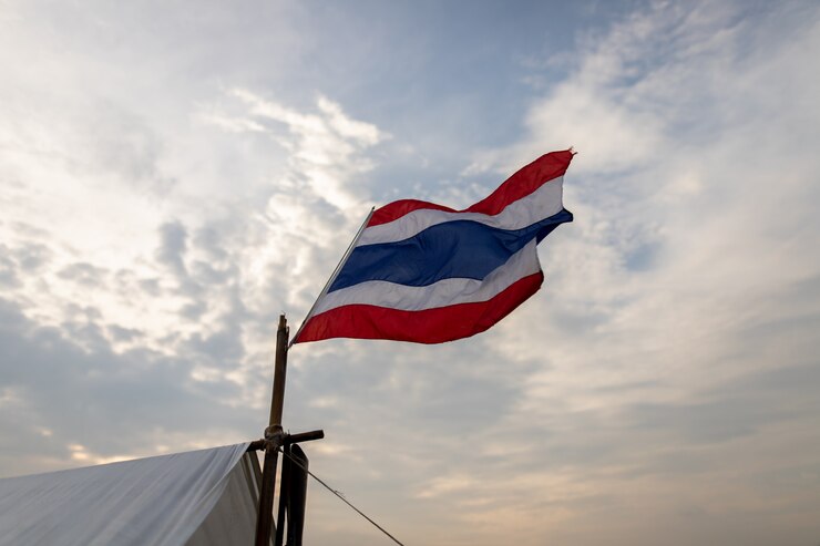 Imagen de agitar la bandera tailandesa de Tailandia con fondo de cielo azul.