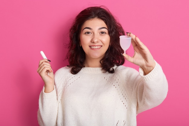 Imagen de una alegre joven enérgica que recomienda usar la copa menstrual durante los días críticos