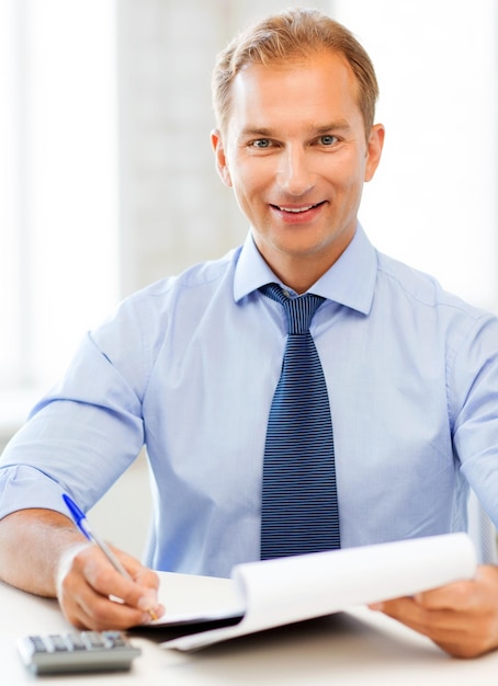 Foto imagen de apuesto hombre de negocios con portátil y calculadora