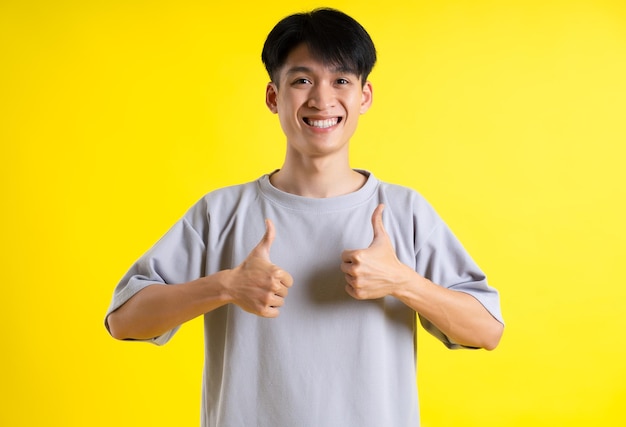 Imagen de un apuesto joven posando sobre un fondo amarillo