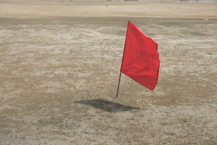 Una imagen de bandera roja en la playa con sombra Señal de prohibición de entrar al mar causada por olas fuertes y altas durante la temporada de monzones