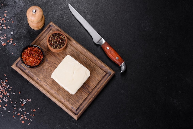 Foto imagen de una barra y queso mozzarella rallado sobre un fondo oscuro