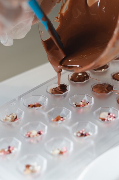 Imagen de batir con chocolate para la preparación de pasteles Glaseado de pasteles dulces Proceso casero con cacao derretir para crear un glaseado para pasteles dulces y chocolate de cerca