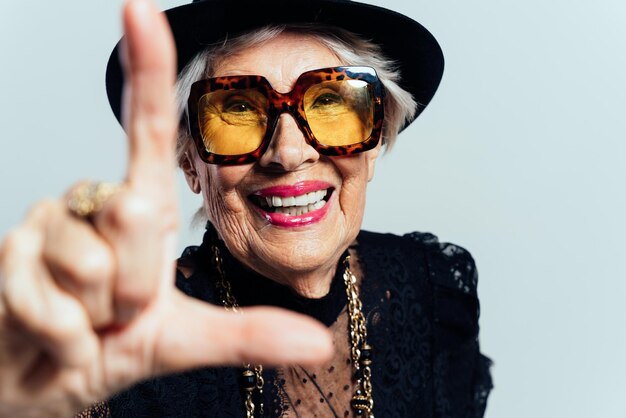 Imagen de una bella y elegante mujer influyente. Cool abuela posando en estudio vistiendo ropa de moda