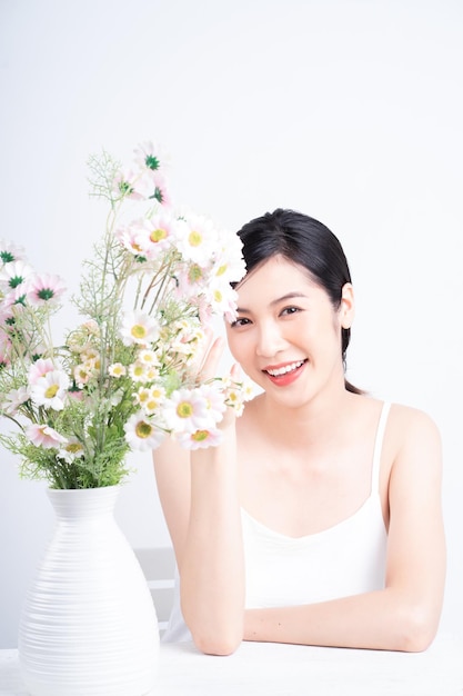 Imagen de belleza de una joven asiática con flores.