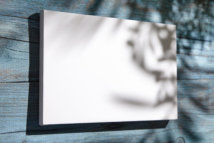 Imagen en blanco de maqueta de lienzo colgada en una pared de madera azul con sombras oscuras de hojas de palma