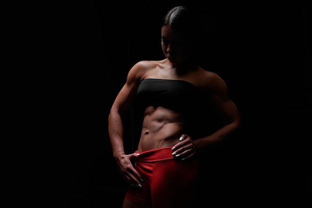 Imagen en blanco y negro de una chica deportiva sobre un fondo negro Concepto de fitness