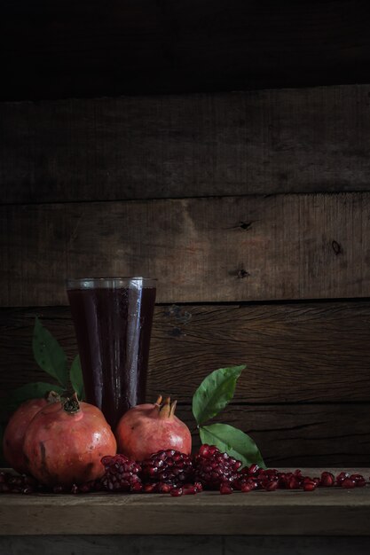 Imagen de bodegones y granada con jugo en vidrio y pila de semillas