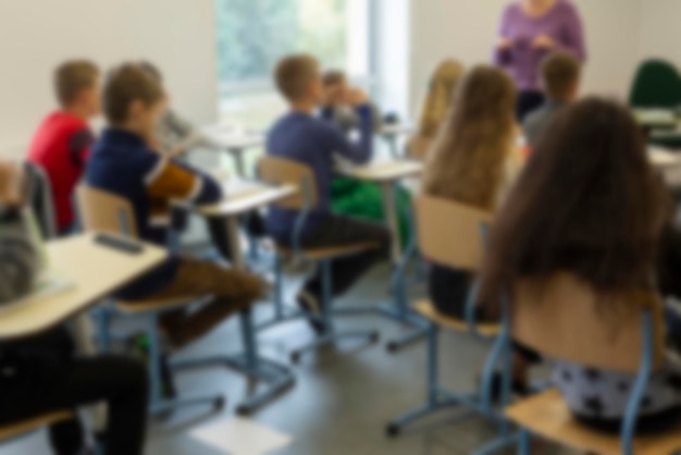 Imagen borrosa de escolares sentados en clase en el fondo de la lección de regreso a la escuela