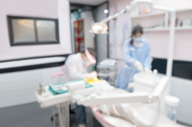 Imagen borrosa foto del dentista y su asistente están trabajando en la clínica.