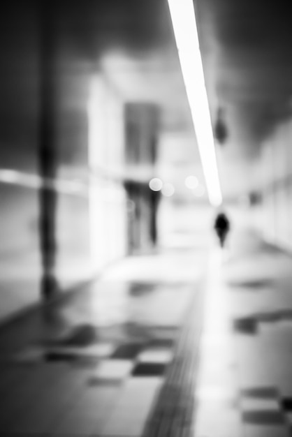 Una imagen borrosa de lente en blanco y negro de una figura humana en movimiento en un túnel