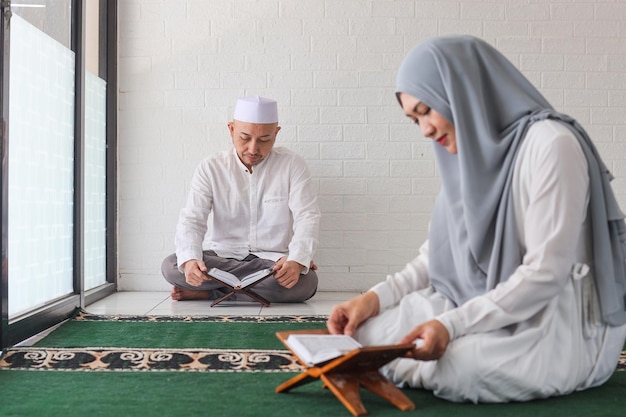 Imagen borrosa de una mujer musulmana y su marido recitando el Corán durante el mes de Ramadán en la mezquita