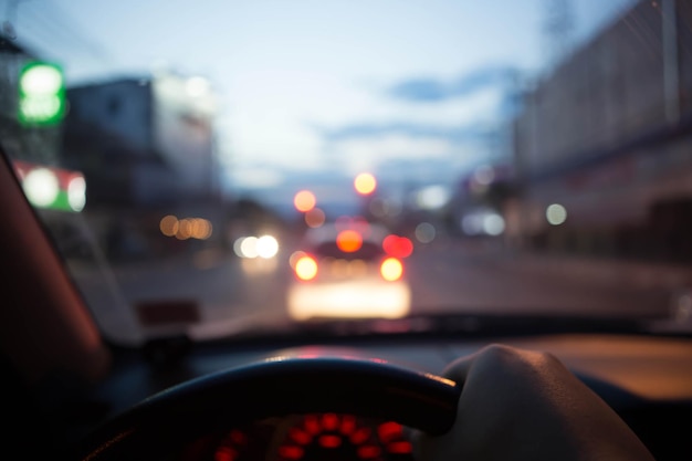 Imagen borrosa de personas que conducen un automóvil por la noche para uso de fondo