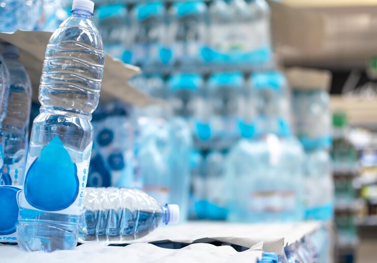 Imagen de botellas de agua almacenadas en los lineales de los supermercados para su venta y consumo