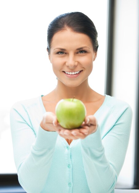 Imagen brillante de ama de casa encantadora con manzana verde