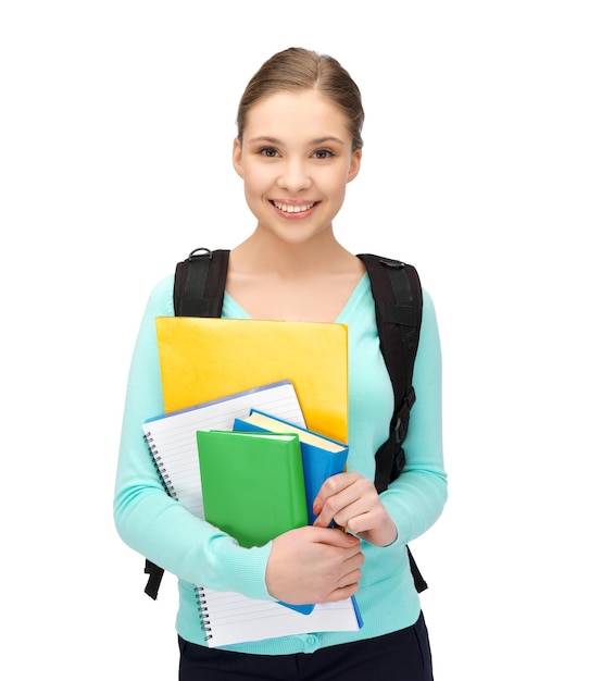 Imagen brillante de estudiante sonriente con libros y mochila.