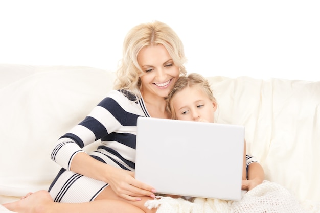 Imagen brillante de feliz madre e hijo con computadora portátil