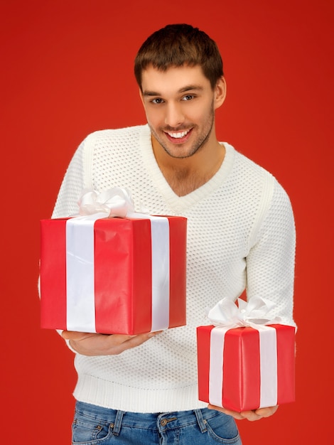 imagen brillante de hombre guapo sosteniendo muchas cajas de regalo.