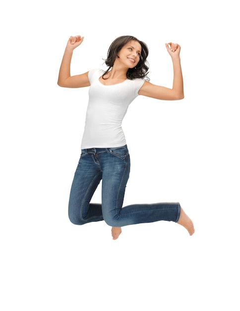 imagen brillante de mujer feliz saltando en camiseta blanca en blanco.