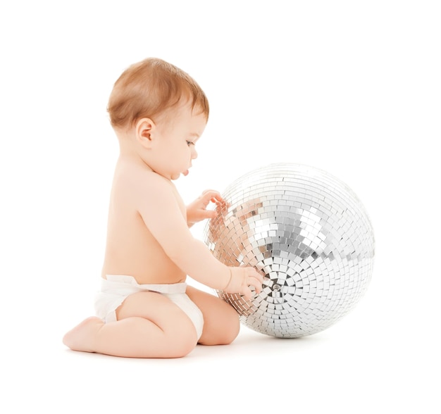 Imagen brillante de niño feliz jugando con bola de discoteca