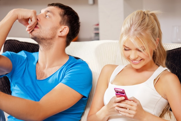 Imagen brillante de pareja en casa con teléfono celular