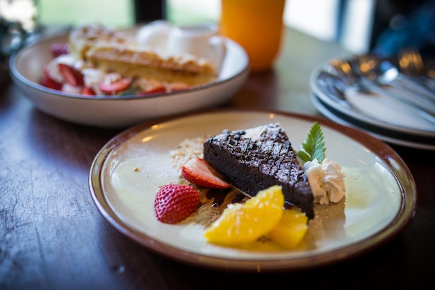 Imagen de los brownies caseros de chocolate amargo y fresa y naranja fresca