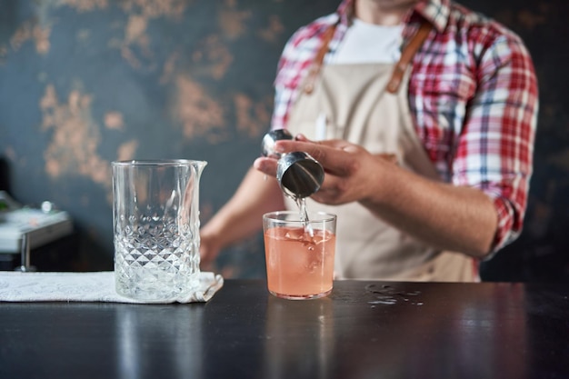 Foto imagen de un cantinero usando una coctelera para hacer un cóctel