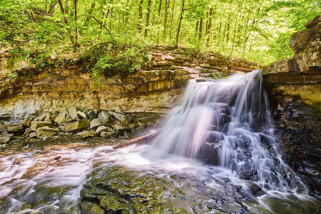 Imagen de cascada con cientos de cascadas sobre acantilados rocosos en bosque verde