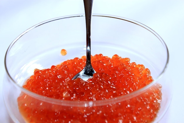 Imagen de caviar rojo en un plato con la cuchara