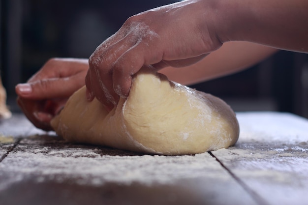 Imagen de cerca del chef de la panadería haciendo masa de pan en la cocina