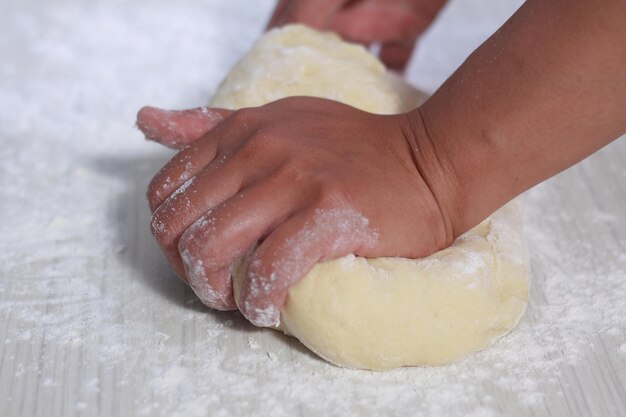 Imagen de cerca del chef de la panadería haciendo masa de pan en la cocina