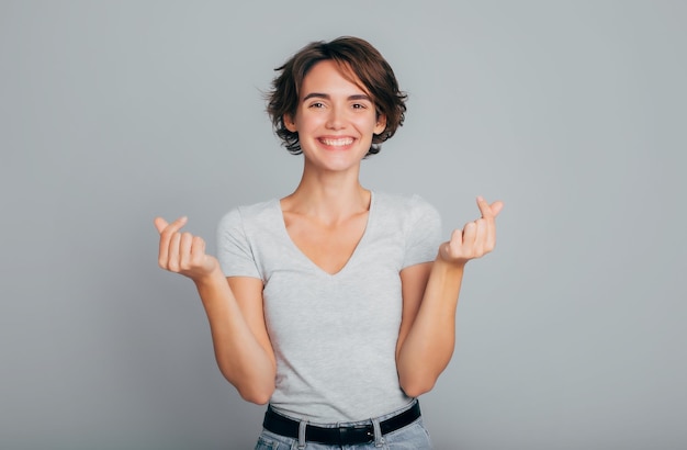 Foto imagen de cerca retrato de una joven mujer bonita sonriente muestra un mini corazón coreano como signo de gesto día de san valentín sentimiento romántico kpop cruzando el gesto del dedo símbolo de emoción romántica