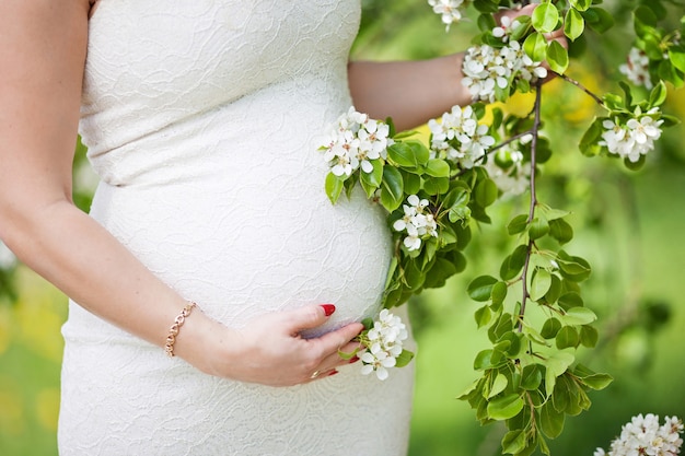Imagen cercana de la mujer embarazada tocando su vientre con las manos