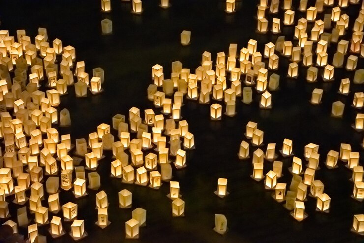 Imagen de la ceremonia japonesa de conmemoración de las bombas atómicas de Hiroshima y Nagasaki con linternas de papel flotando sobre el agua en la noche.